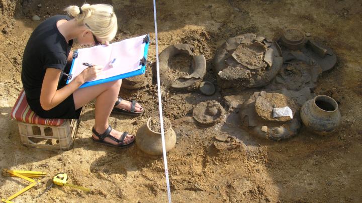 Archeolog dokumentuje odkryty grób w Domasławiu z dużą zawartością naczyń ceramicznych. Fot. Archiwum Zespołu Archeologicznych Badań Ratowniczych IAE PAN Wrocław