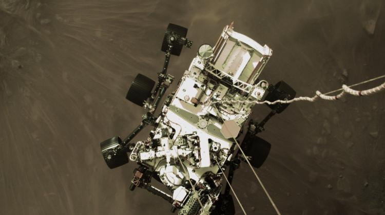Lądowanie łazika Perseverance na powierzchni Marsie. Zdjęcie z kamery zamontowanej na platformie, z której na linach wypuszczono łazika w końcowym etapie lądowania. Źródło: NASA/JPL-Caltech.