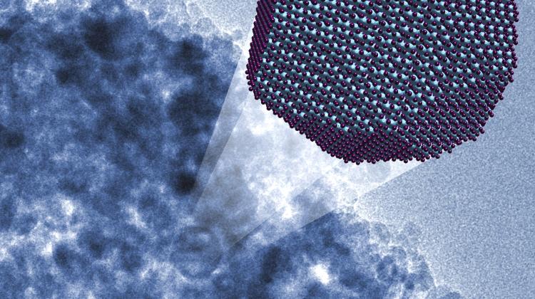 Trójwymiarowa wizualizacja nanocząstki korundu. W tle rzeczywiste  zdjęcie mikroskopowe (kolory sztuczne). (Źródło: IFJ PAN, MPI Kofo)
