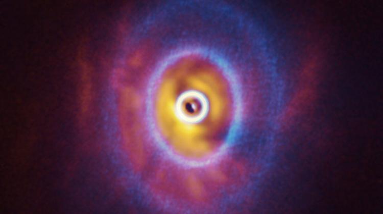 Nałożone na siebie obrazy dysku protoplanetarnego w systemie GW Orionis uzyskane przez radioteleskop ALMA oraz teleskop VLT. Źródło: ESO/Exeter/Kraus et al., ALMA (ESO/NAOJ/NRAO).