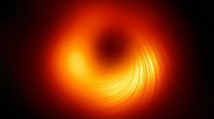 Nowa wersja obrazu supermasywnej czarnej dziury w galaktyce M87. Linie pokazują kierunek polaryzacji, która ma związek z polem magnetycznym wokół obiektu. Źródło: EHT Collaboration.