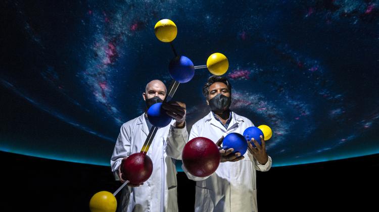 Współautorzy badań dr Arunlibertsen Lawzer i dr Thomas Custer prezentują modele cząsteczek interesujących z punktu widzenia astrochemii. Zdjęcie zostało wykonane w nowoczesnym planetarium Centrum Nauki Kopernik. źródło: IChF PAN, fot: Grzegorz Krzyżewski