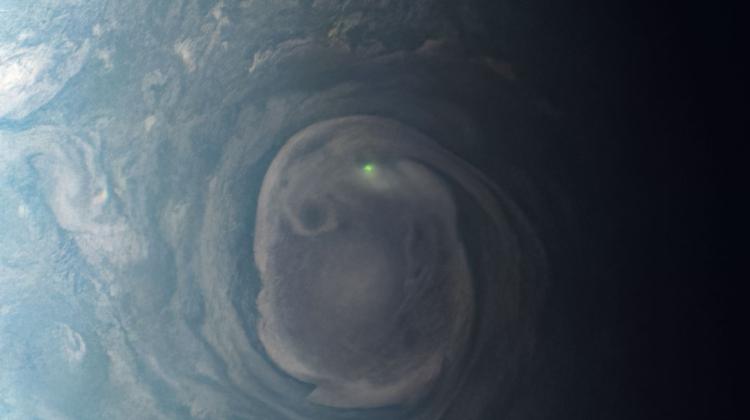 Wir wokół północnego bieguna Jowisza, na którym widać zielony punkt – błyskawicę. Obraz przetworzony na podstawie danych z sondy Juno. Źródło: NASA/JPL-Caltech/SwRI/MSSS / przetworzenie obrazu: Kevin M. Gill